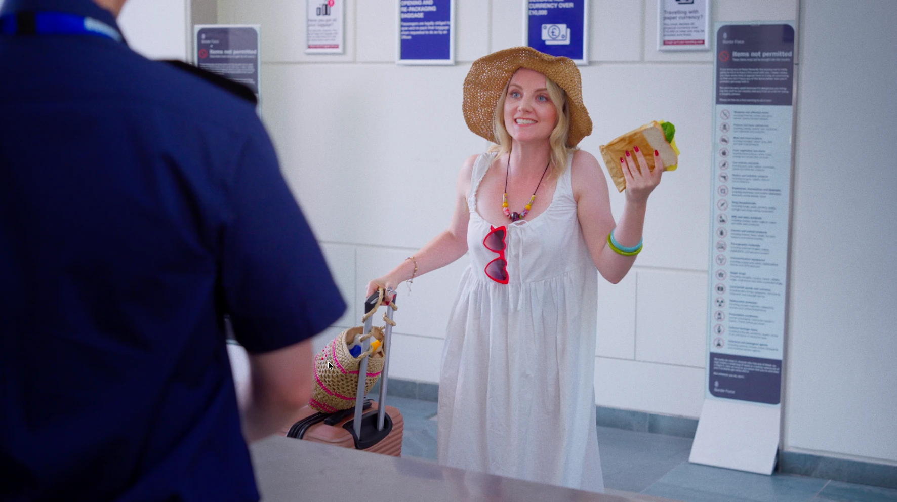 Evanna Lynch at the customs desk in Nothing to Declare, a trophy hunting comedy directed by Andrew Davies
